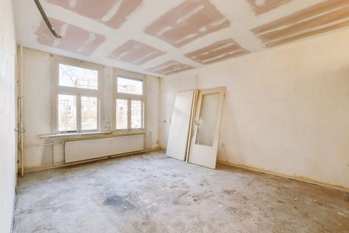 Weiß lackiertes Holzfenster mit Sprossen in einer Altbaufassade